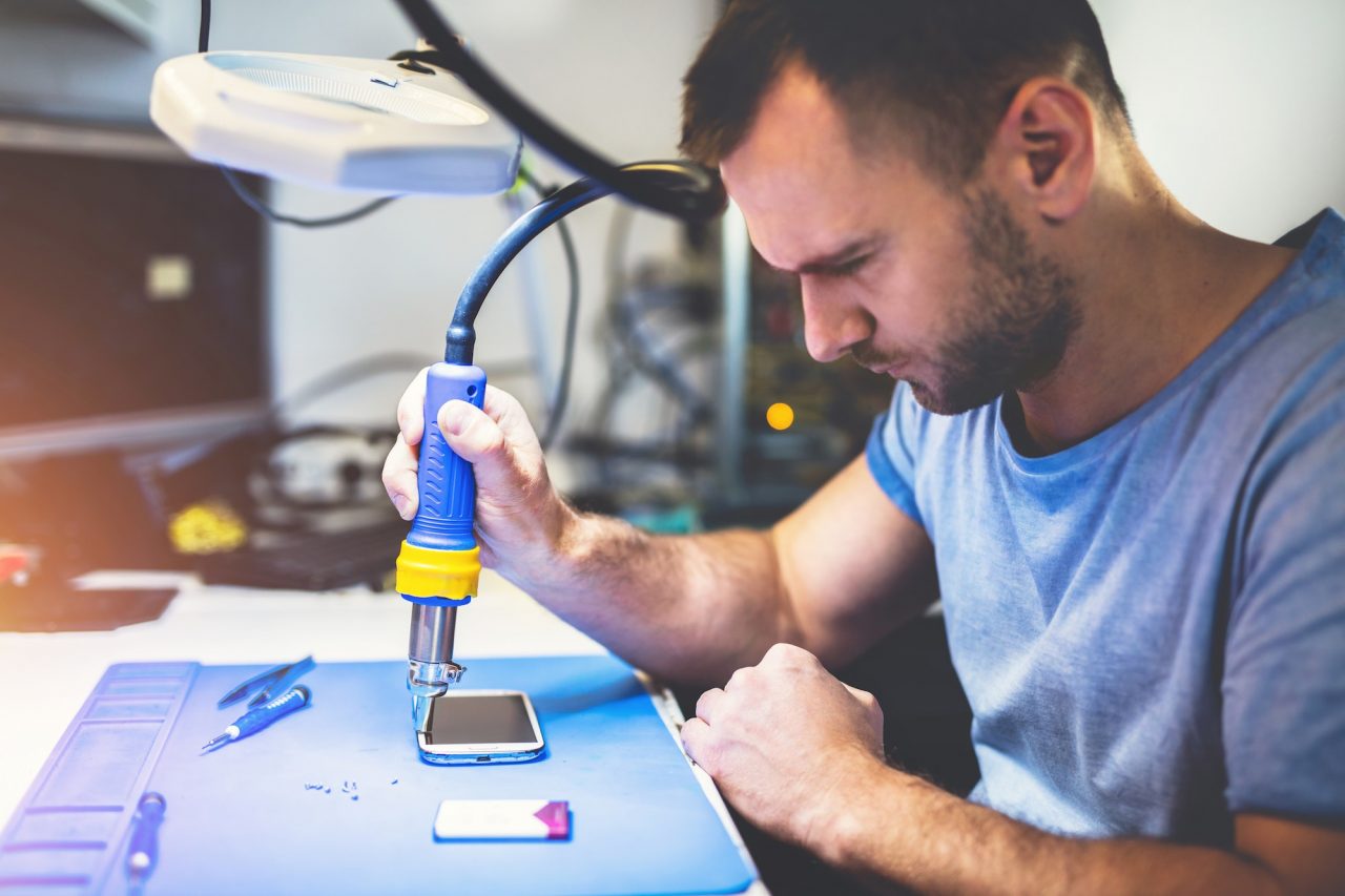 Man repairing smartphone at workplace.jpg