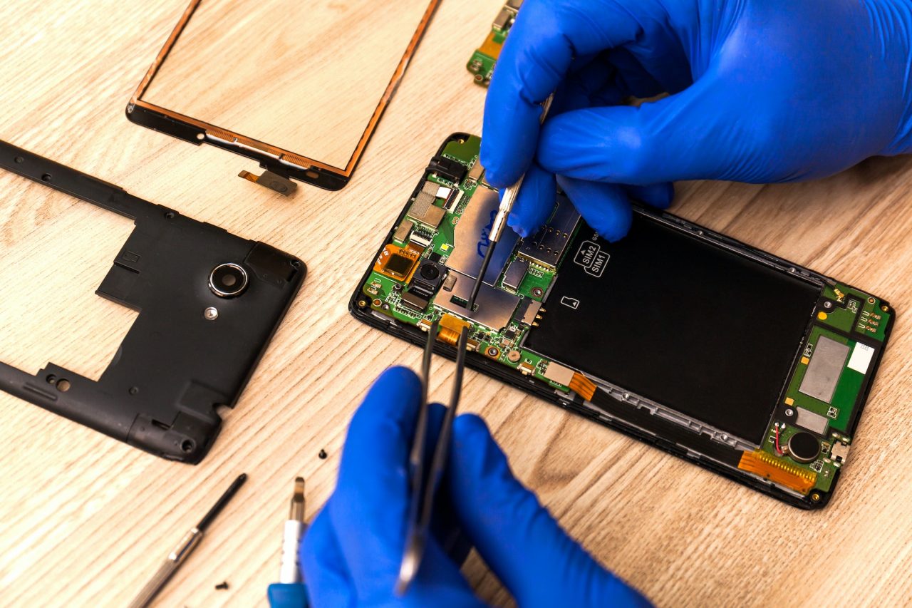 The technician repairing the smartphone s motherboard in the workshop on the table 1 1.jpg