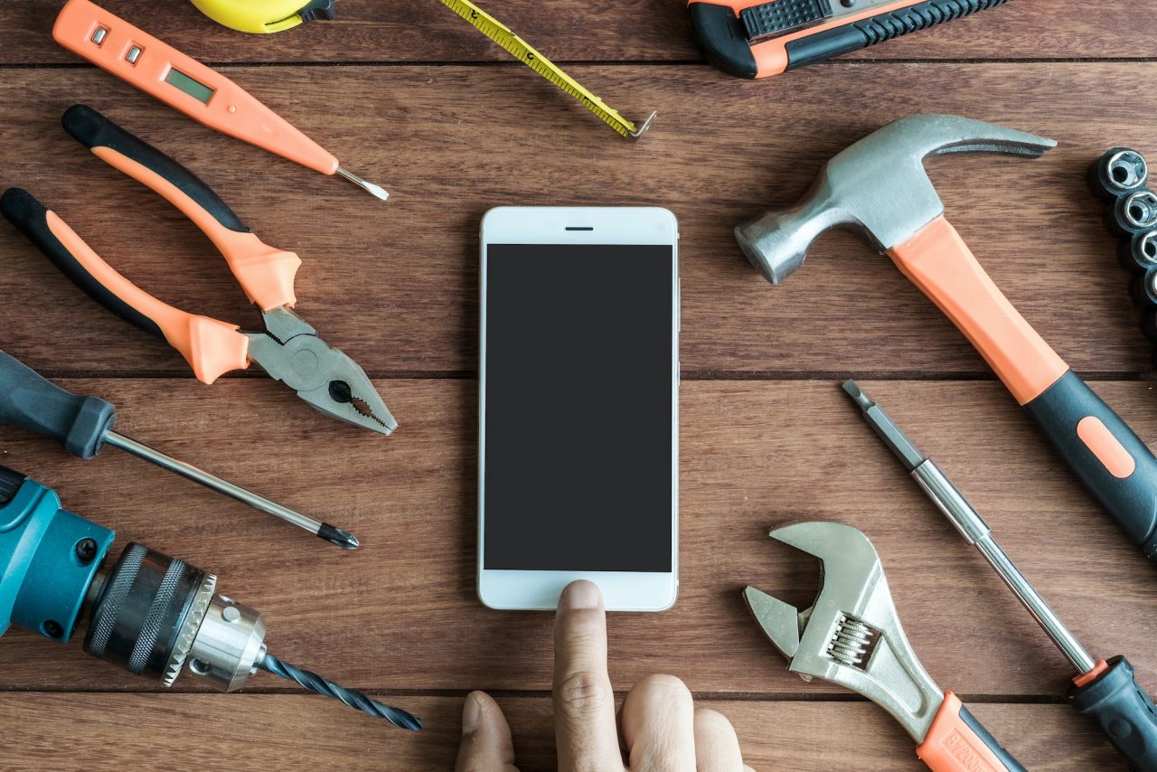 Tools and smart phone on wooden background.jpg
